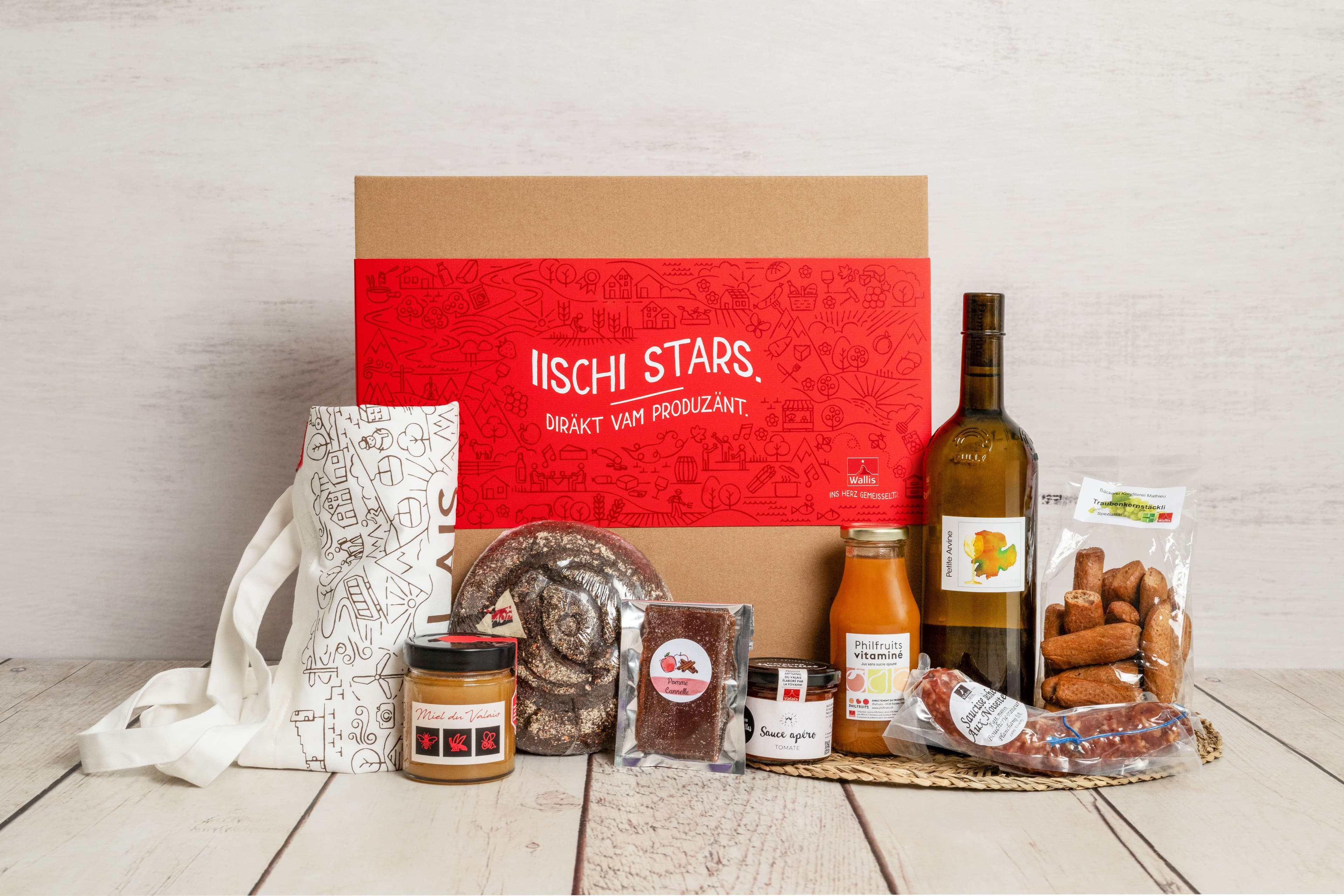 Coffret rouge garni de vin, charcuterie et produits du terroir valaisan