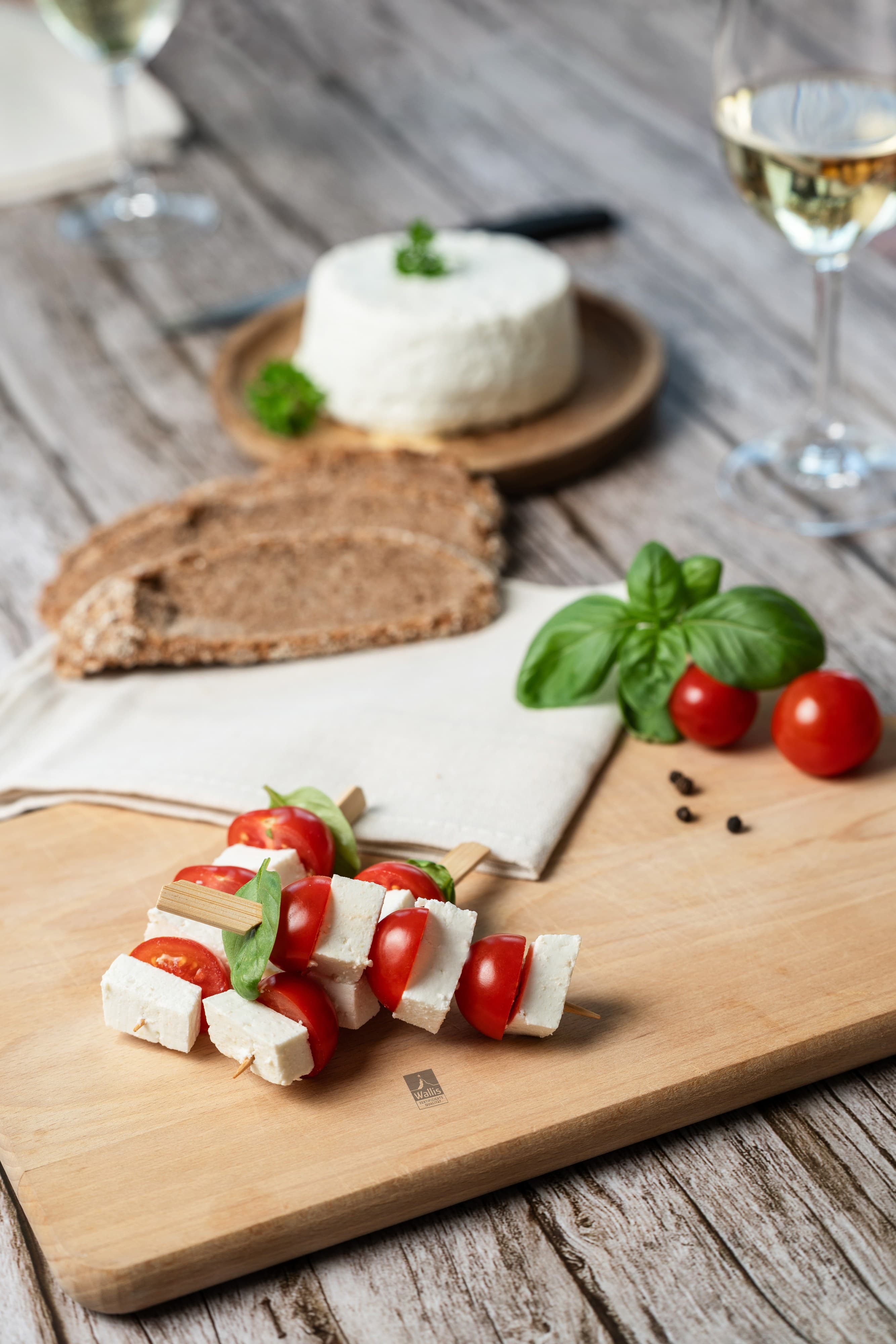 Fromage frais, pain et tomates cerises sur une planche en bois