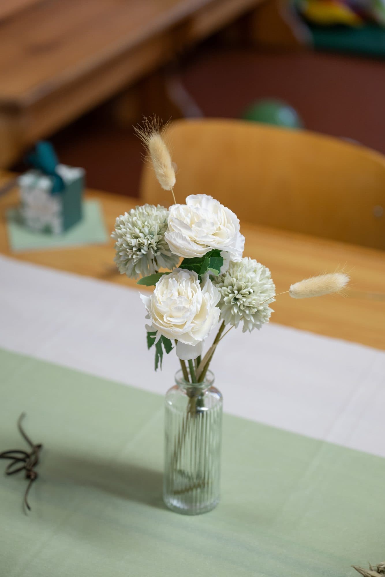 Un bouquet de fleurs blanches dans un vase, sur la table de fête