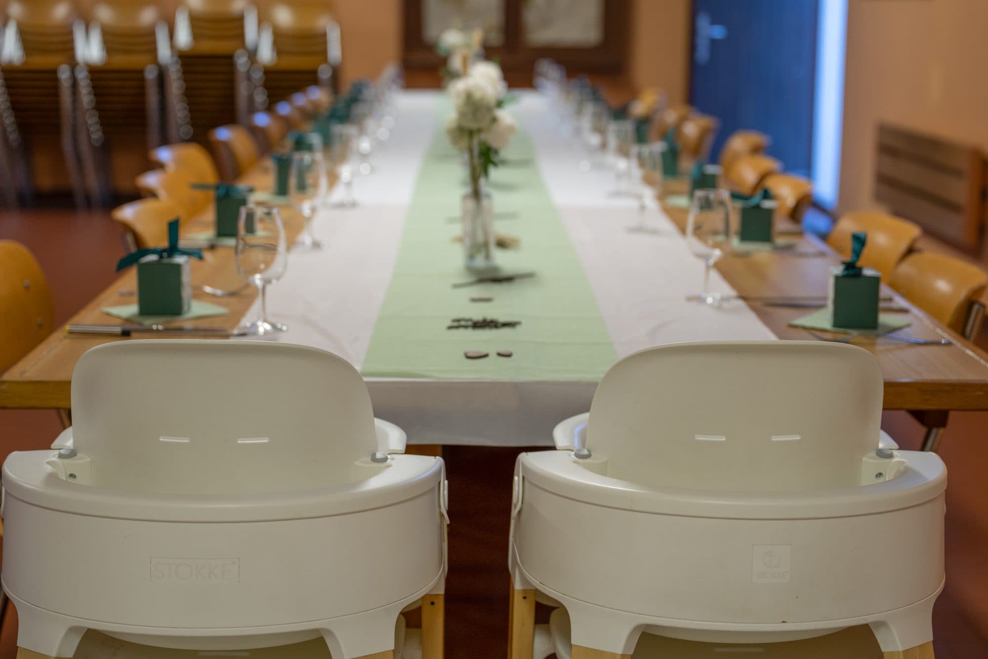 La table de fête dressée en longueur, deux chaises hautes au premier plan