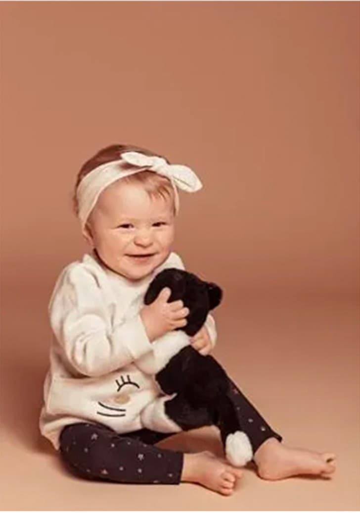 Une fillette souriante avec sa peluche