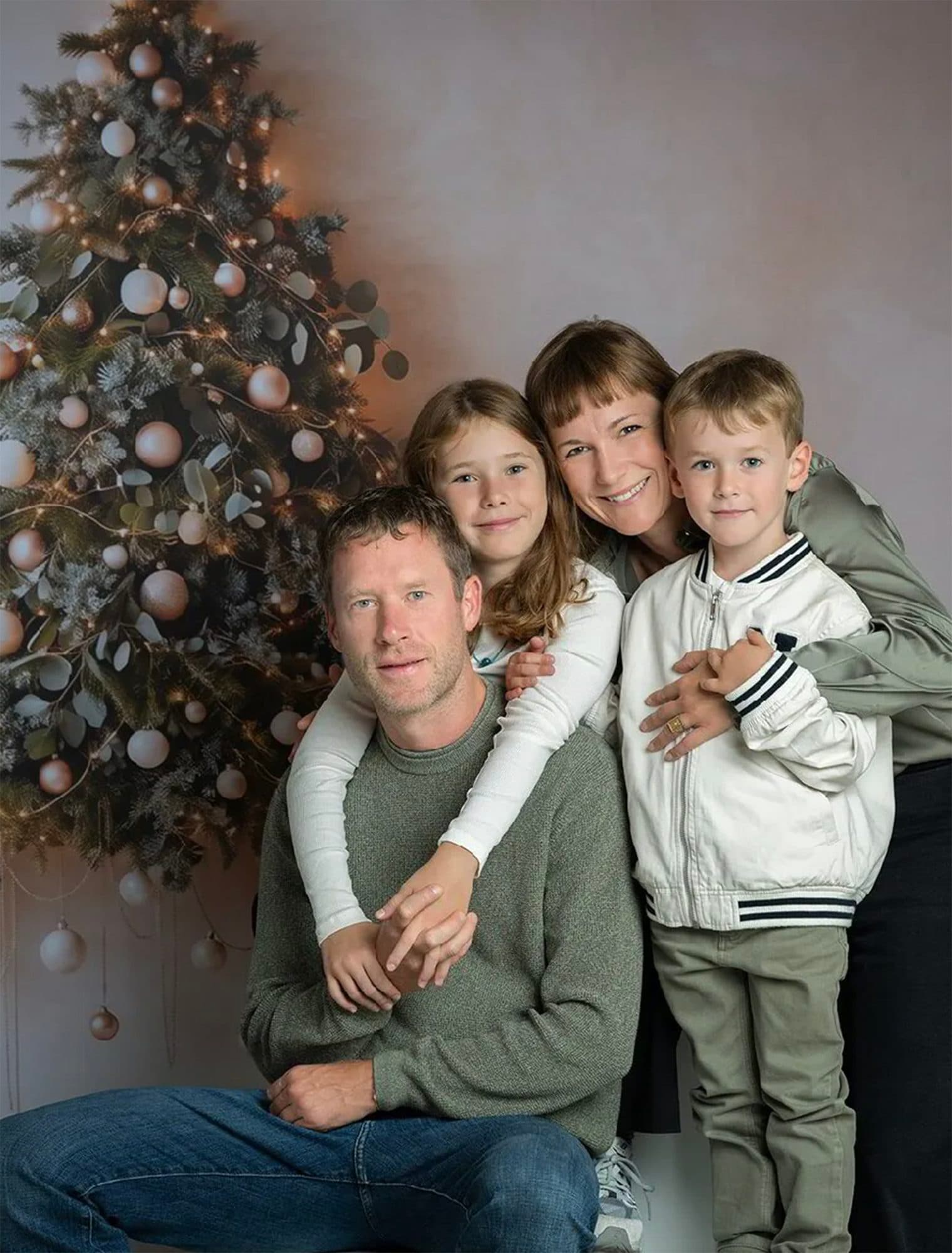 Décor Le Grand Sapin : une famille serrée devant un sapin de Noël aux boules claires