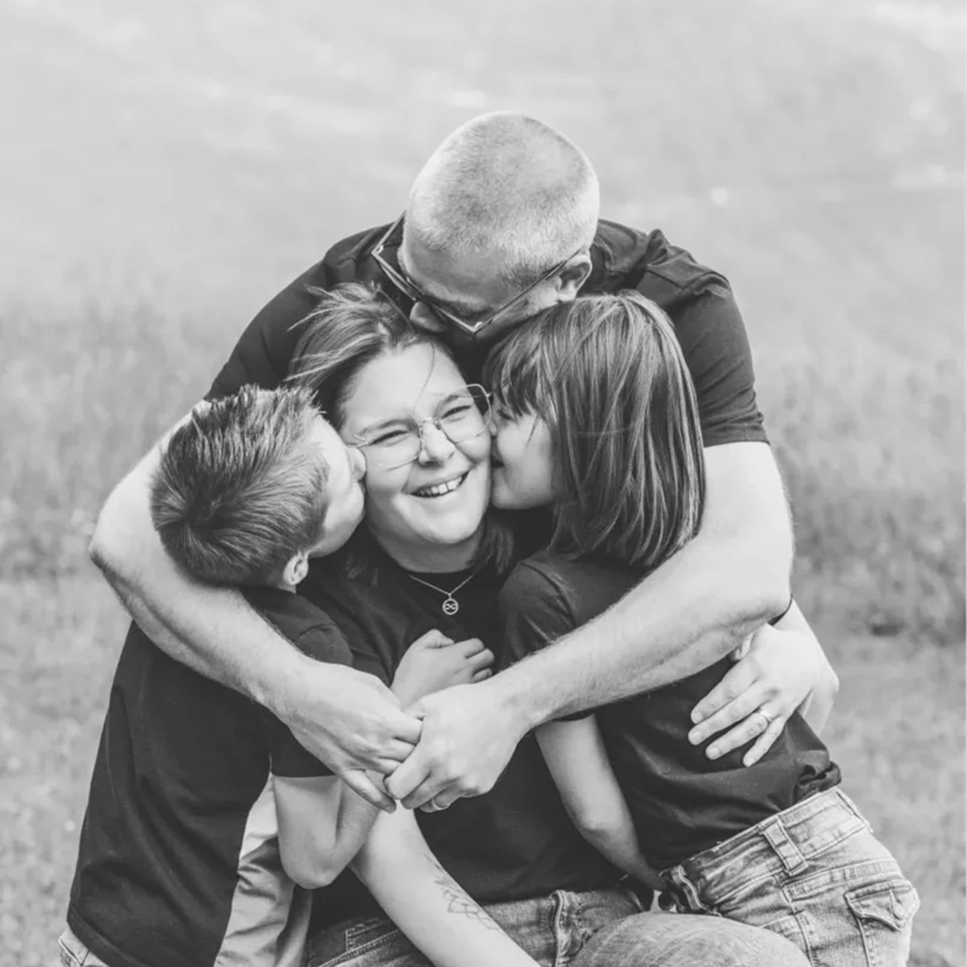 Une famille serrée dans les bras, en noir et blanc
