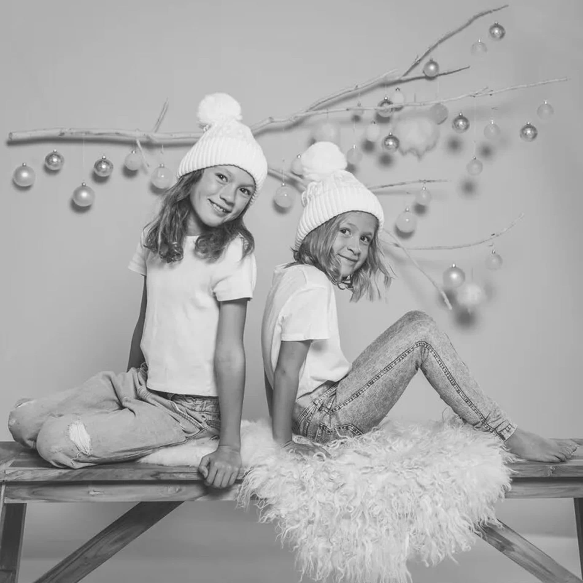 Deux sœurs en bonnets blancs assises sur un banc, en noir et blanc