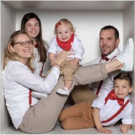Une famille habillée de rouge et de blanc, serrée dans une case du cube géant