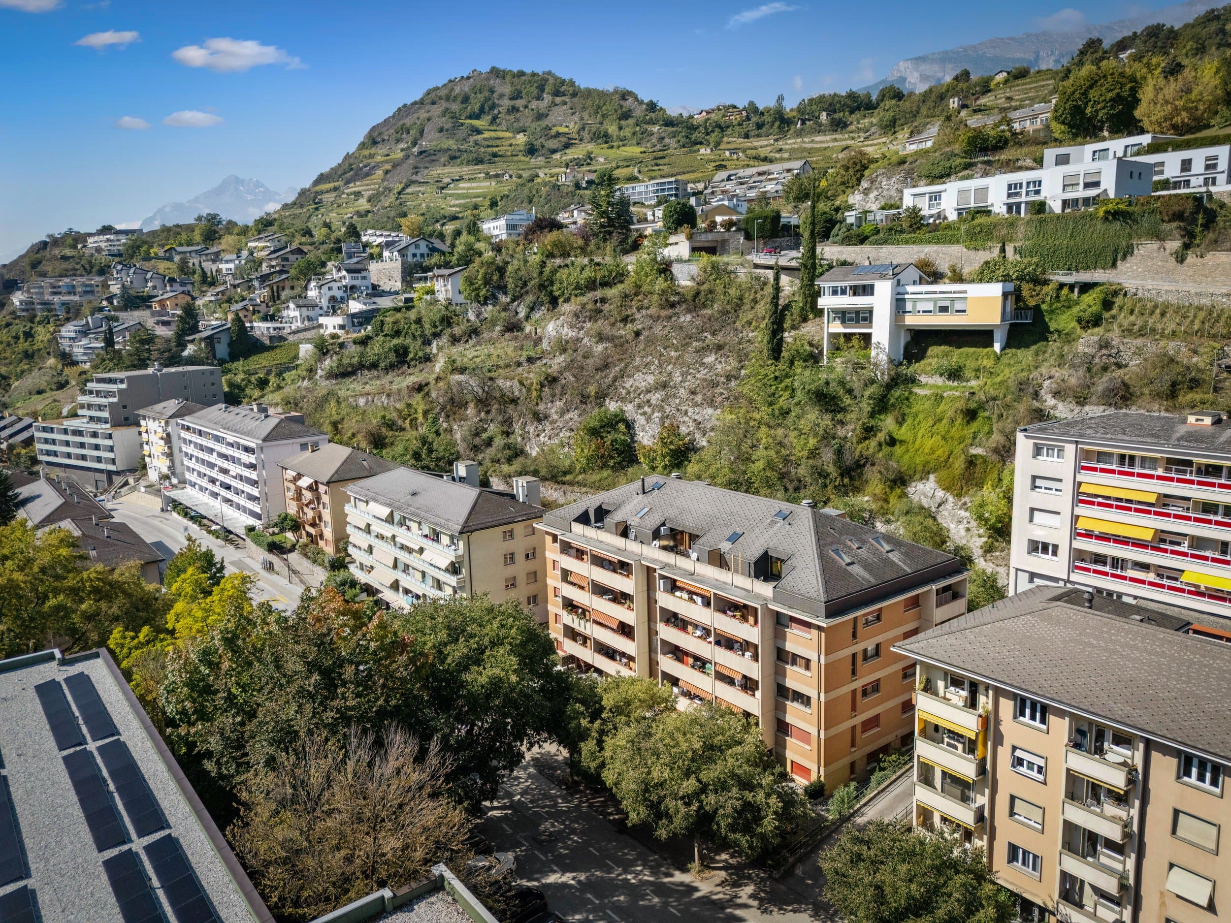 Vue au drone d’immeubles de logements de l’avenue du Petit-Chasseur à Sion, au pied d’une colline de vignes
