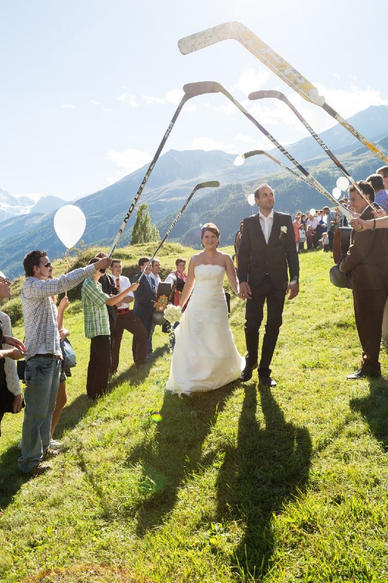 Haie d’honneur de crosses de hockey pour la sortie des mariés, en montagne