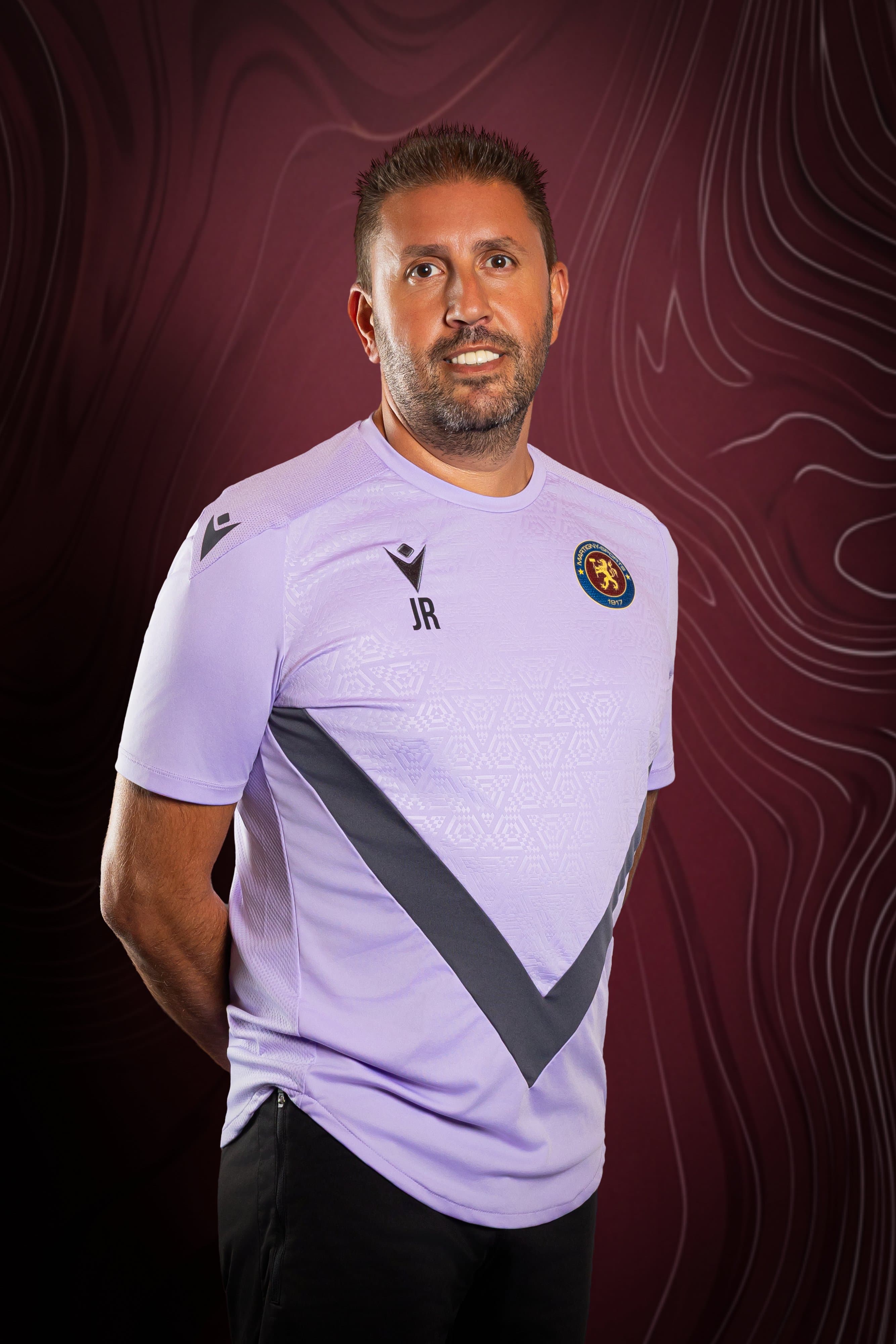 Portrait d’un membre de l’équipe du Martigny-Sports en maillot lilas, sur fond bordeaux