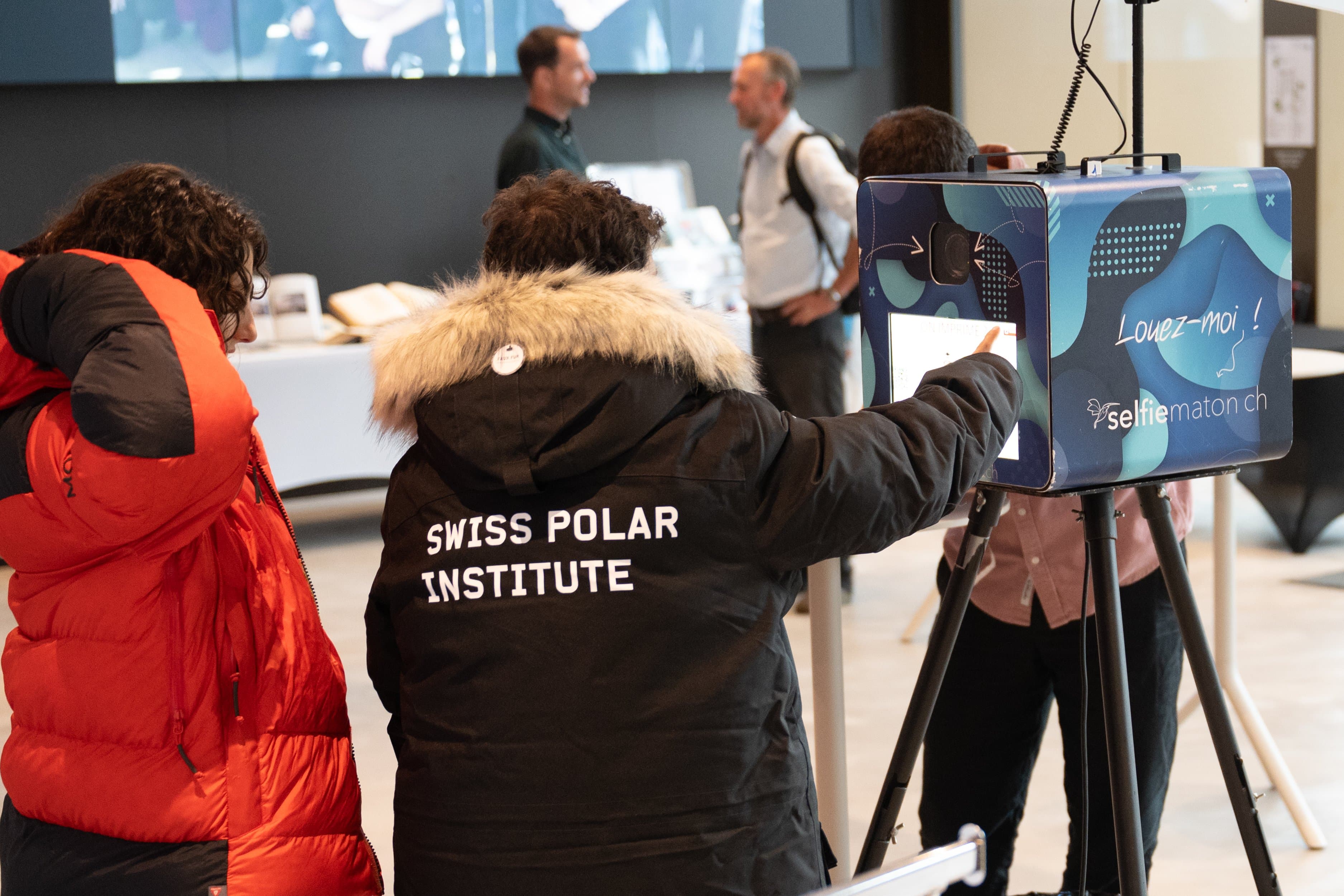 Participantes devant le photomaton Selfiematon, l’une porte une veste Swiss Polar Institute